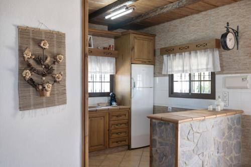 une cuisine avec des armoires en bois et un réfrigérateur blanc dans l'établissement Cortijo Entrepinares, à Roche