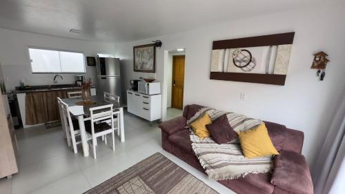 a living room with a couch and a kitchen at Casa espaçosa - Luar da Guarda in Palhoça