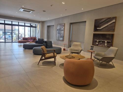 a lobby with couches and chairs in a building at Flat Aeroporto Congonhas (Apto 714) in Sao Paulo