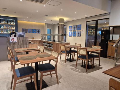 a restaurant with wooden tables and chairs in a kitchen at Flat Aeroporto Congonhas (Apto 714) in Sao Paulo