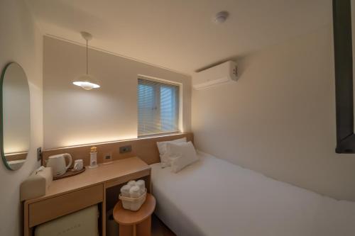 a bedroom with a bed and a desk and a window at Hotel DALSTAIR Seoul Jongno in Seoul