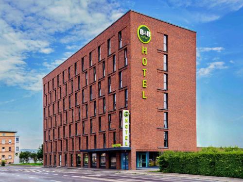 a tall red brick building with a sign on it at B&B Hotel Mainz-Hbf in Mainz