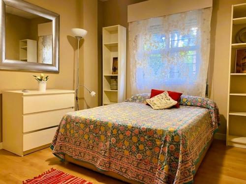 a bedroom with a bed and a dresser and a mirror at Acogedor Apart de 2 dormitorios en C.Expo, SEVILLA in Mairena del Aljarafe