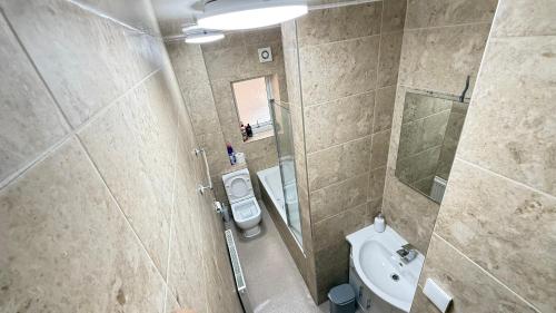 a small bathroom with a toilet and a sink at Luxurious Apartment "N22" in London
