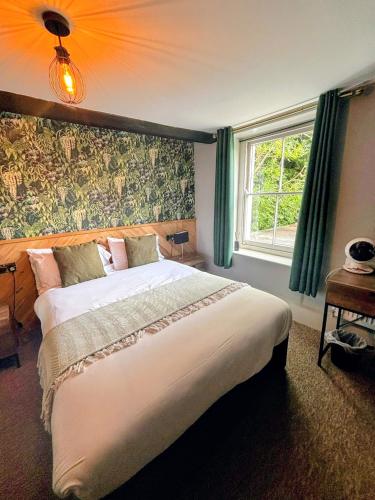 a bedroom with a large bed and a window at The Old Mill Hotel in Salisbury