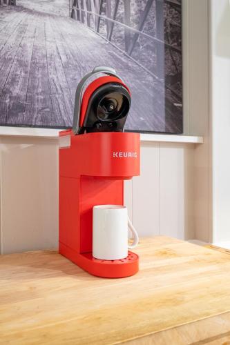 a red coffee maker with a cup on a table at Basement 1BR! Pet Friendly with Weekly Deals in Acworth