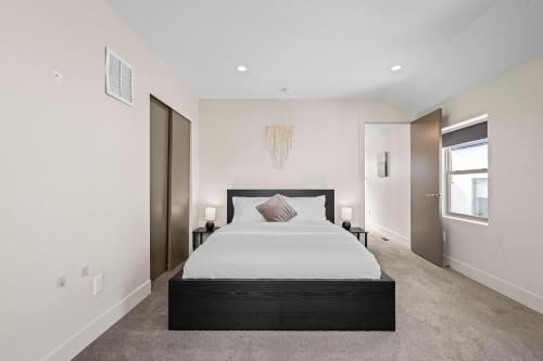 una camera da letto con un letto grande con lenzuola bianche di Modern Townhome For Long Stays Near Sloans Lake a Denver