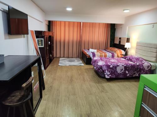 a hotel room with two beds and a kitchen at Skyline in La Paz