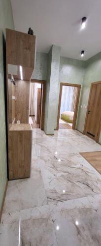 Una habitación grande con suelo de mármol y un baño. en Green apartment Velingrad, en Velingrad