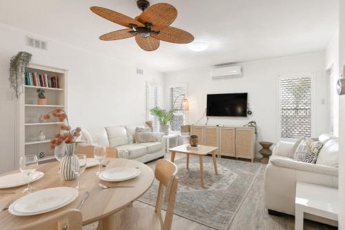 a living room with a table and a ceiling fan at Rockingham Beach Breeze 2BR Retreat in Rockingham