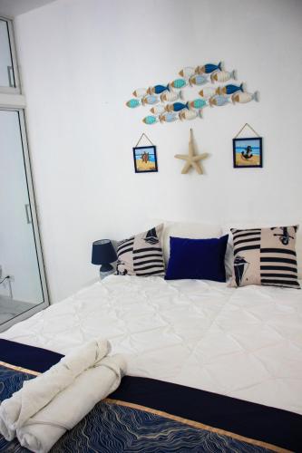 a bedroom with a large white bed with pillows and a starfish at Residencia Bambou in Juan Dolio