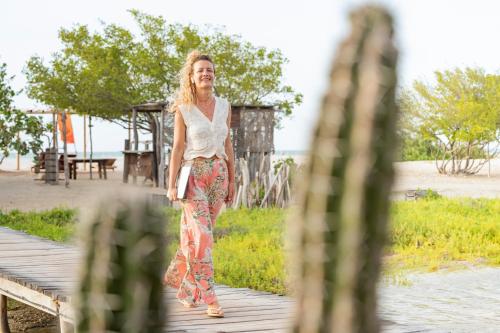 a woman walking on a boardwalk near the beach at Watu Kite House in Mayapo