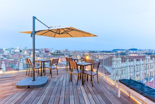 a rooftop deck with tables and chairs and an umbrella at Galerias Nightlife Fashion Flats in Porto