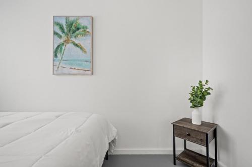 a bedroom with a bed and a table with a palm tree at 65 Condado by Otium in San Juan