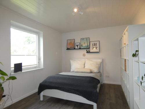 una cama en una habitación con ventana en fewo1846 - Haus Hygge - Bungalow mit Garten und 2 Schlafzimmern, en Flensburg