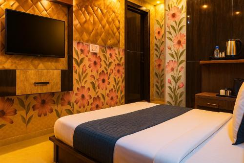 a hotel room with a bed and a tv at Hotel Rajnandani Palace by IQ Hotels - Steps from Ram Mandir, Ayodhya in Ayodhya