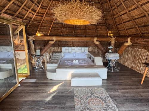 una camera con un letto in una capanna di paglia di Aero Glamping Hotel Pereira a Pereira