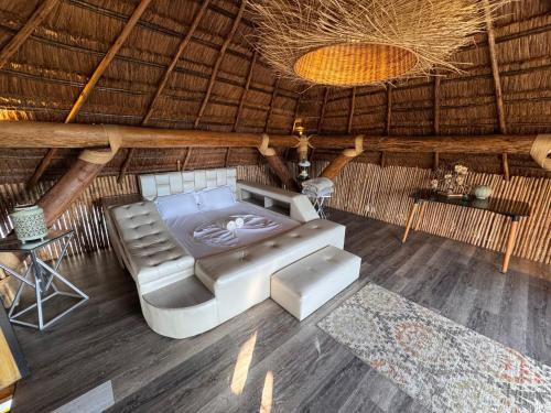 a room with a couch and a bed in a hut at Aero Glamping Hotel Pereira in Pereira