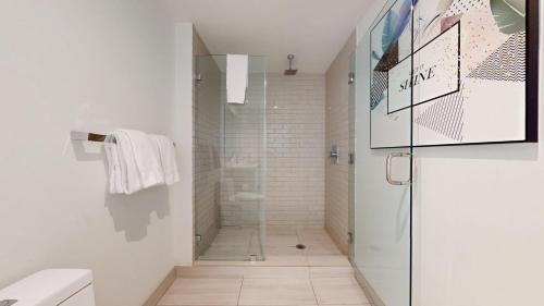 a bathroom with a walk in shower next to a glass door at Hyde Beach House 3BR2BA in Hollywood
