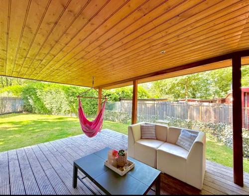 a porch with a white couch and a hammock at Ermwood Cottage in Erm