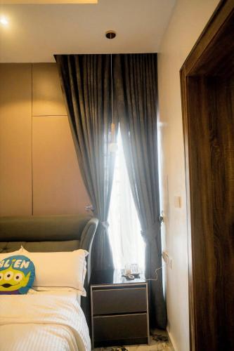 a bedroom with a bed with a blue curtain at Azraa 2 Bedroom Luxury Apartment in Awka