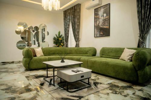 a living room with a green couch and a table at Azraa 2 Bedroom Luxury Apartment in Awka