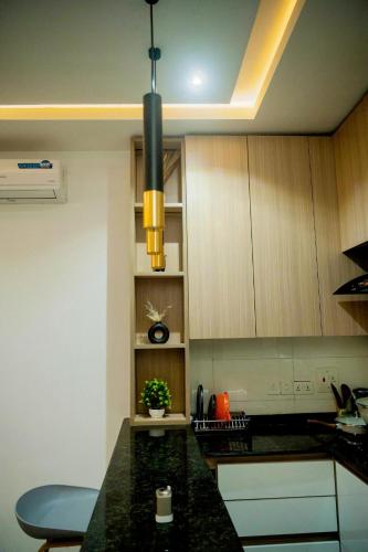 a kitchen with a black counter top and wooden cabinets at Azraa 2 Bedroom Luxury Apartment in Awka