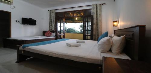 a bedroom with a large bed and a window at ayurvedamountainvilla in Nikawatawana