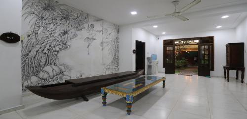 a living room with a black couch and a table at ayurvedamountainvilla in Nikawatawana