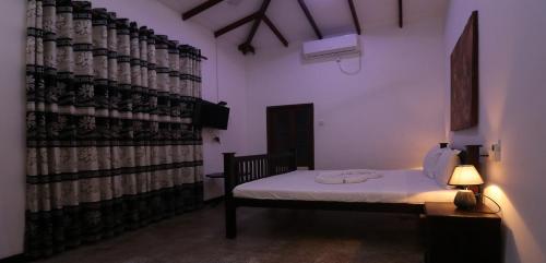 a room with a bed and a wall of wine bottles at ayurvedamountainvilla in Nikawatawana