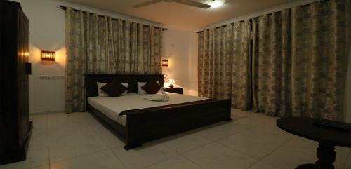 a bedroom with a bed and a large window at ayurvedamountainvilla in Nikawatawana