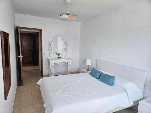 - un lit blanc avec 2 oreillers bleus dans une chambre dans l'établissement Casa Pinto, à Santa Cruz de la Palma