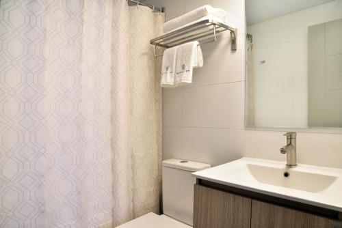 a bathroom with a sink and a shower curtain at Apart Hotel HW Compañia in Santiago
