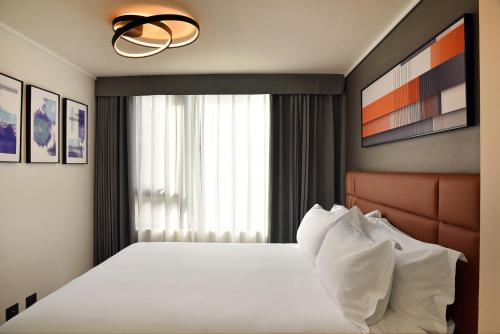 a bedroom with a bed and a large window at Apart Hotel HW Compañia in Santiago