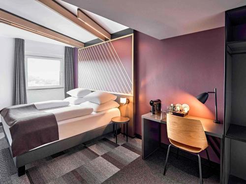 a bedroom with a bed and a table and a chair at B&B Hotel Hamm in Hamm