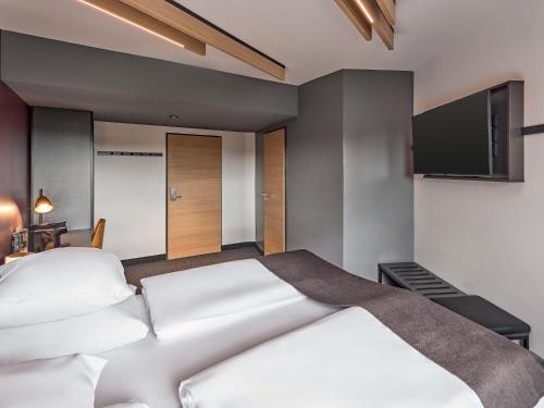 a bedroom with a bed and a flat screen tv at B&B Hotel Hamm in Hamm