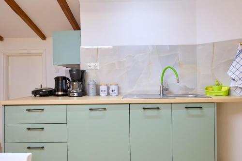 a kitchen with white cabinets and a sink at Cozy Sofita In Chios Island in Chios