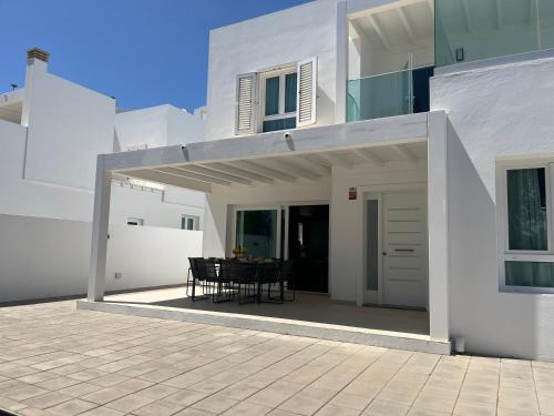Casa blanca con patio con mesa en Casa Millo, en Costa Teguise