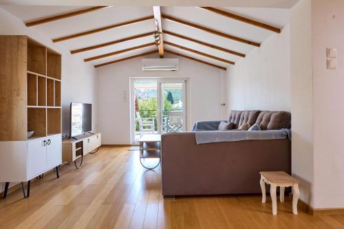 a living room with a couch and a tv at Cozy Sofita In Chios Island in Chios
