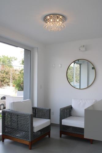 a living room with two chairs and a mirror at Apto de duas suítes com vista mar - 100 metros da praia em Canasvieiras in Florianópolis