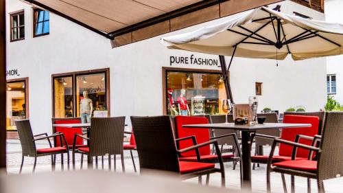 a restaurant with tables and chairs and an umbrella at Zin Senfter Residence in San Candido