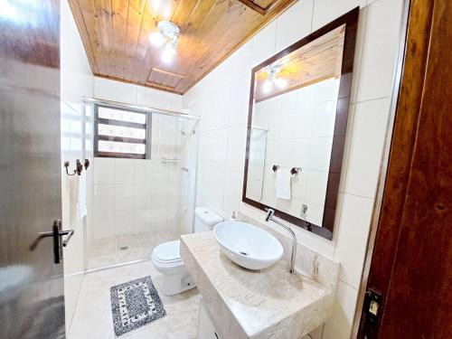 a bathroom with a sink and a toilet and a shower at Charme nas montanhas com lareira in Campos do Jordão