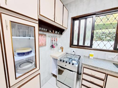 a small kitchen with a stove and a sink at Charme nas montanhas com lareira in Campos do Jordão