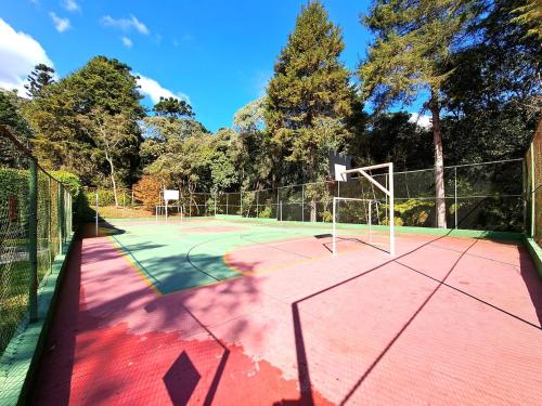 a tennis court with a net on top of it at Charme nas montanhas com lareira in Campos do Jordão