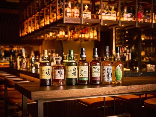 a group of bottles of alcohol sitting on a bar at Dusit Thani Kyoto in Kyoto