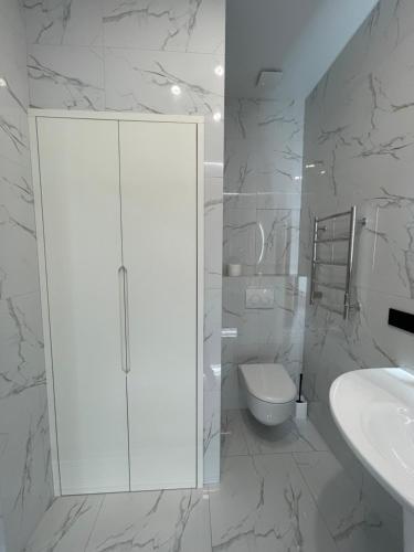 ein weißes Badezimmer mit Toilette und Waschbecken in der Unterkunft Апартаменты с панорамным видом возле моря in Odessa