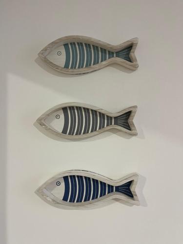 a group of three wooden fish on a table at Casa A'Bareis in Polignano a Mare