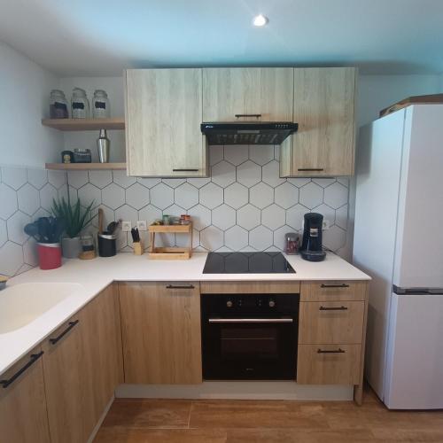a kitchen with a stove and a white refrigerator at Villa Flow - Villa familiale proche plage in Orient Bay