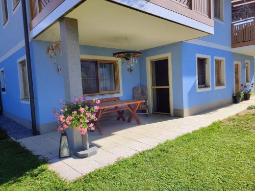 a blue house with a wooden bench on a patio at Fewo Puxberg in Niederwölz