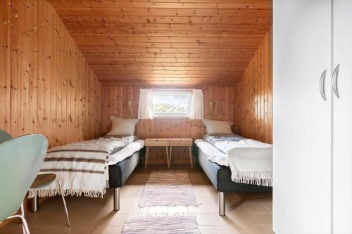 two beds in a small room with a window at LN1965-Hirtshals-Klinken-11 in Hirtshals